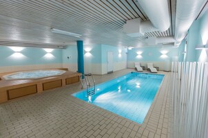 Una piscina techada, sillones reclinables de piscina
