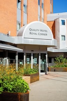 Entrada de un hotel con un cartel que dice 'Quality Hotel Royal Corner'.