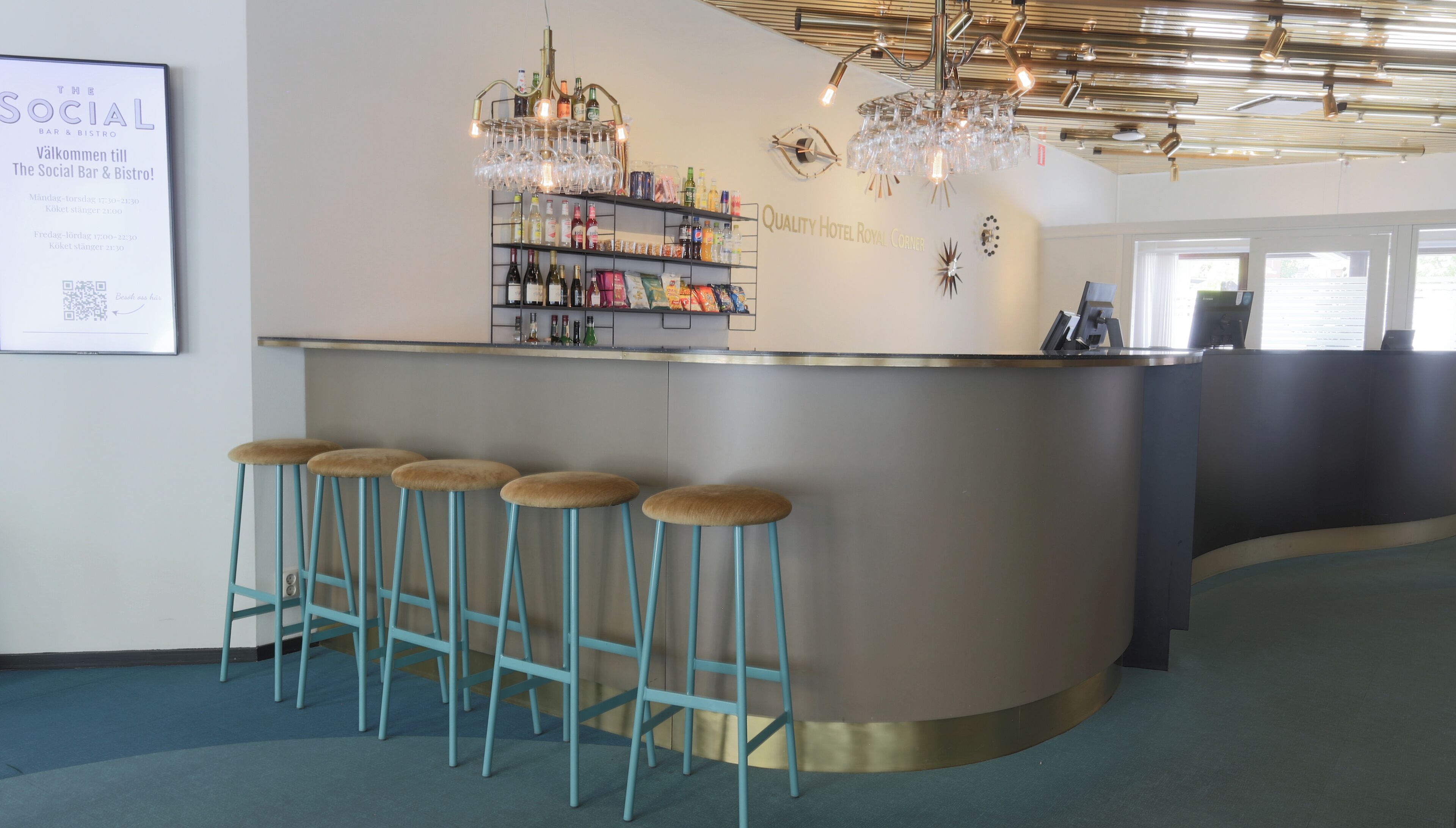 A bar area with a counter, stools, and a variety of bottles and glasses.