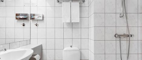 A modern bathroom with a sink, toilet, and shower.