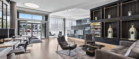 Eine moderne Lobby mit Sitzgelegenheit, einer Bar und einem großen Fenster mit Blick nach außen.
