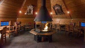A wooden interior with a central fireplace, wooden walls, and a high ceiling. - Scandic Lillehammer Hotel (Lillehammer)