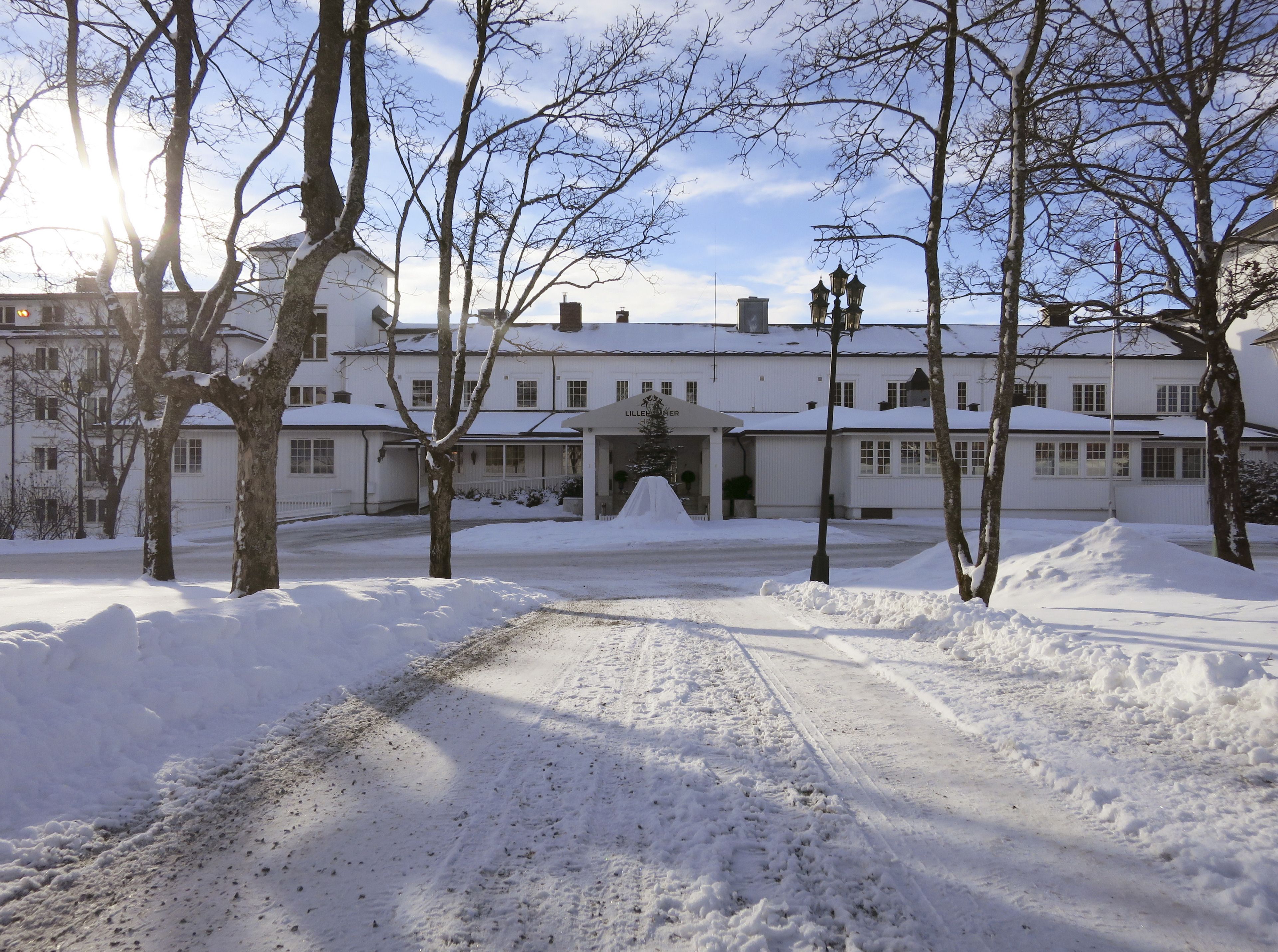 Un edificio cubierto de nieve con un camino pavimentado que lleva a la entrada.