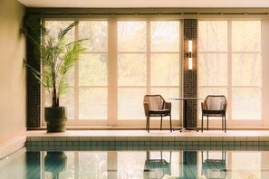A pool area with a potted plant, two chairs, and a tiled wall. - Scandic Lillehammer Hotel (Lillehammer)