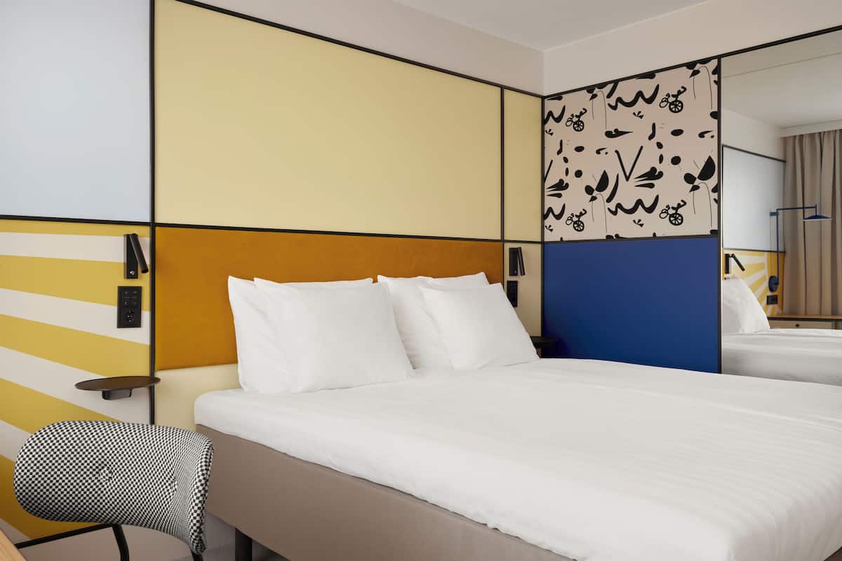 Une chambre d’hôtel avec un grand lit, une chaise et un bureau.