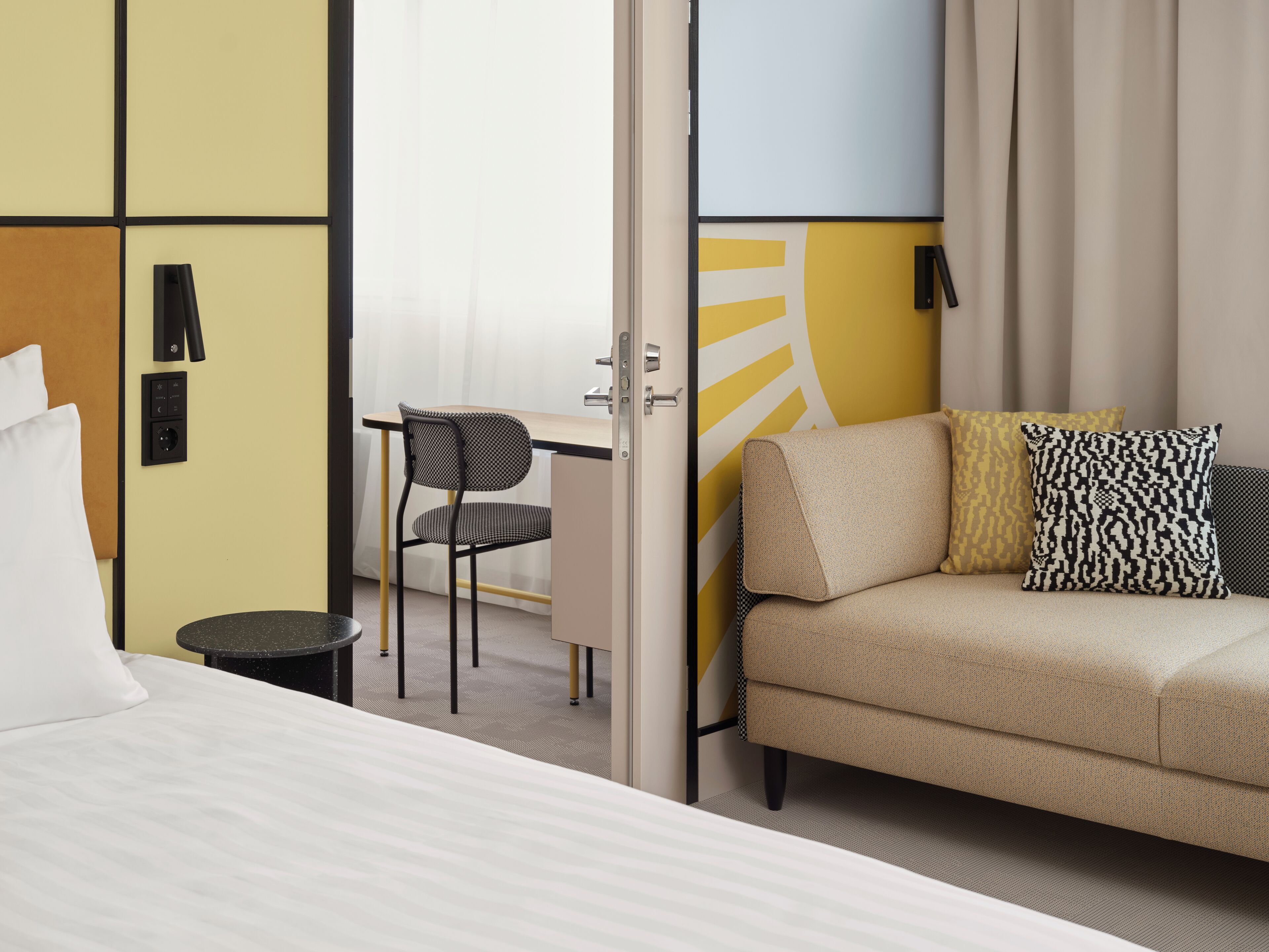 Una habitación de hotel con una cama, un sofá, un escritorio y una silla.