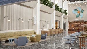 Un hall d’entrée moderne comprenant un comptoir d’accueil, un espace salon et une boutique ouverte 24 heures sur 24, 7 jours sur 7.
