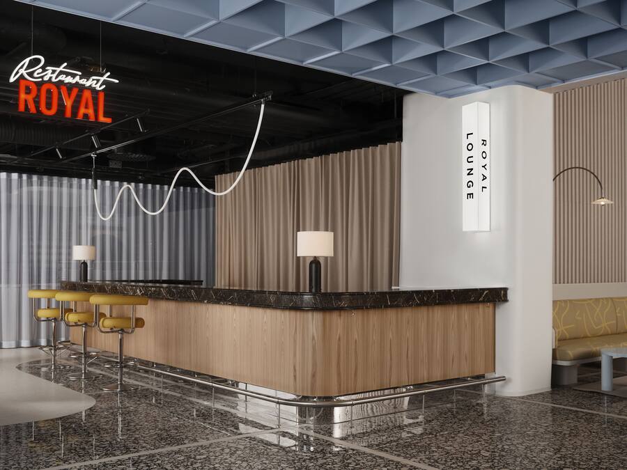 A modern bar area with a marble countertop, wooden paneling, and a lounge seating area.