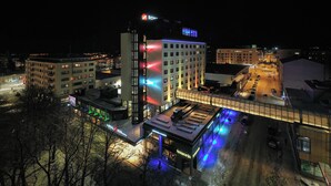 Un hôtel à plusieurs étages, doté d’un espace extérieur couvert et d’un parking.