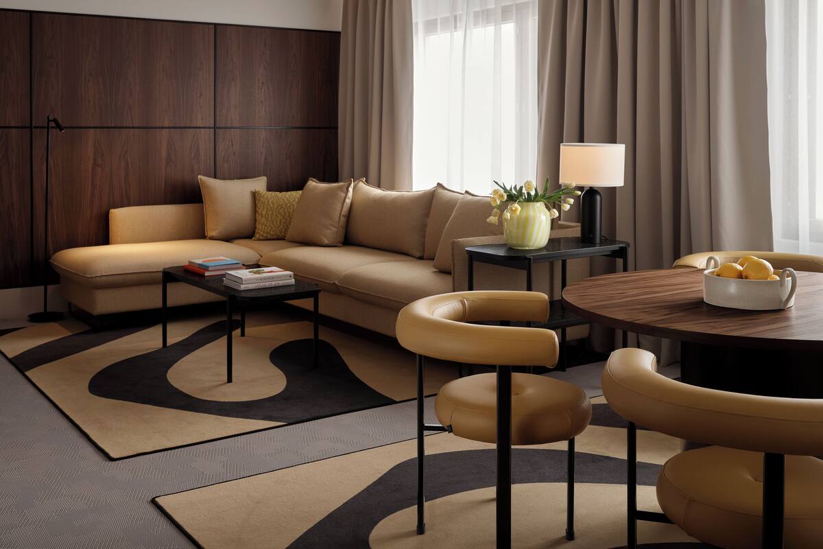 Un salon moderne comprenant un canapé, une table basse et un coin repas avec des chaises et une table.