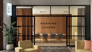 Un espace de travail moderne, doté d’une grande table et de chaises, d’une plante en pot et d’une enseigne indiquant : « ESPACE DE TRAVAIL VALO ».