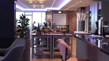 A modern bar area with a bar counter, stools, and a seating area with chairs.
