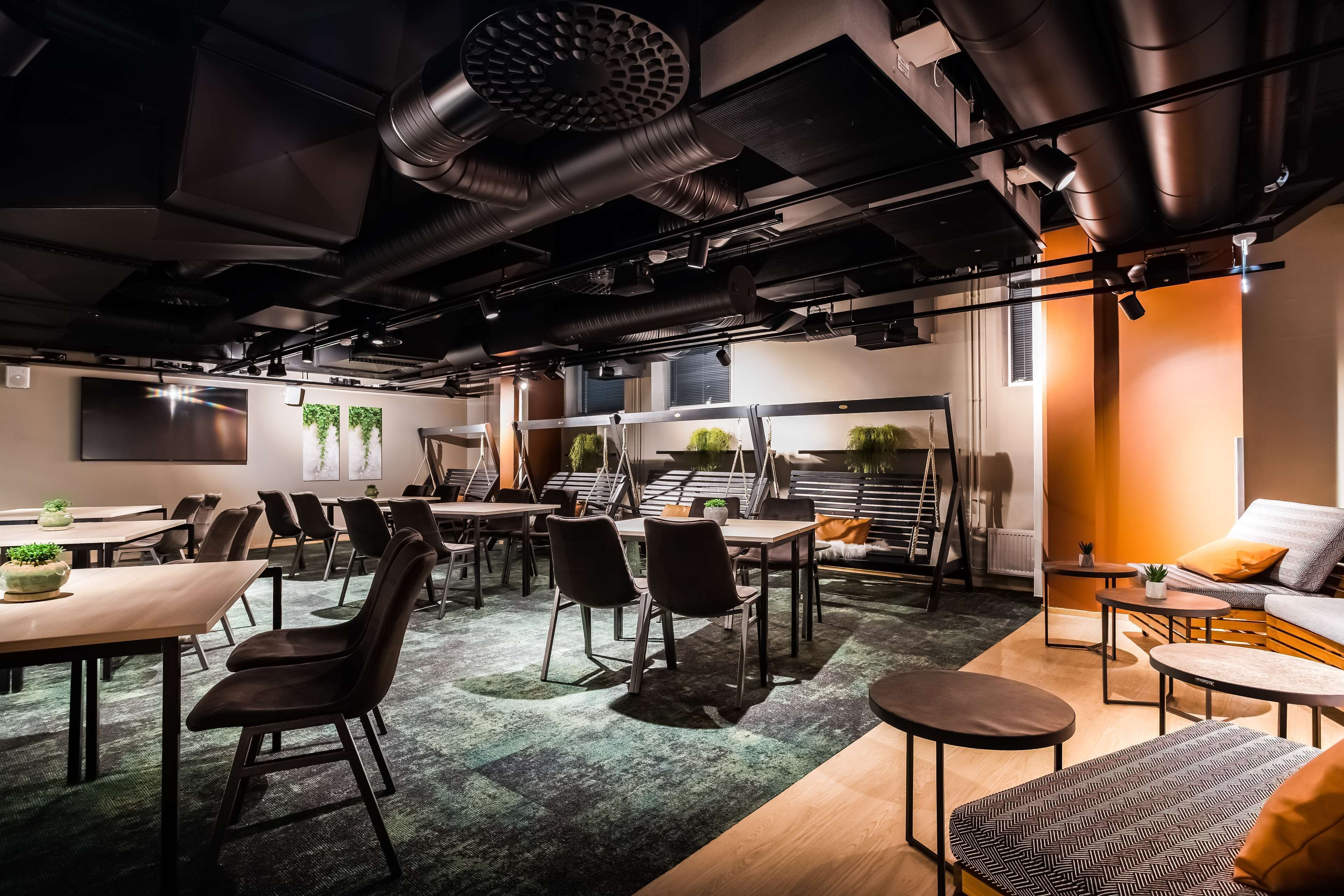 A modern conference room with tables, chairs, and a sofa.