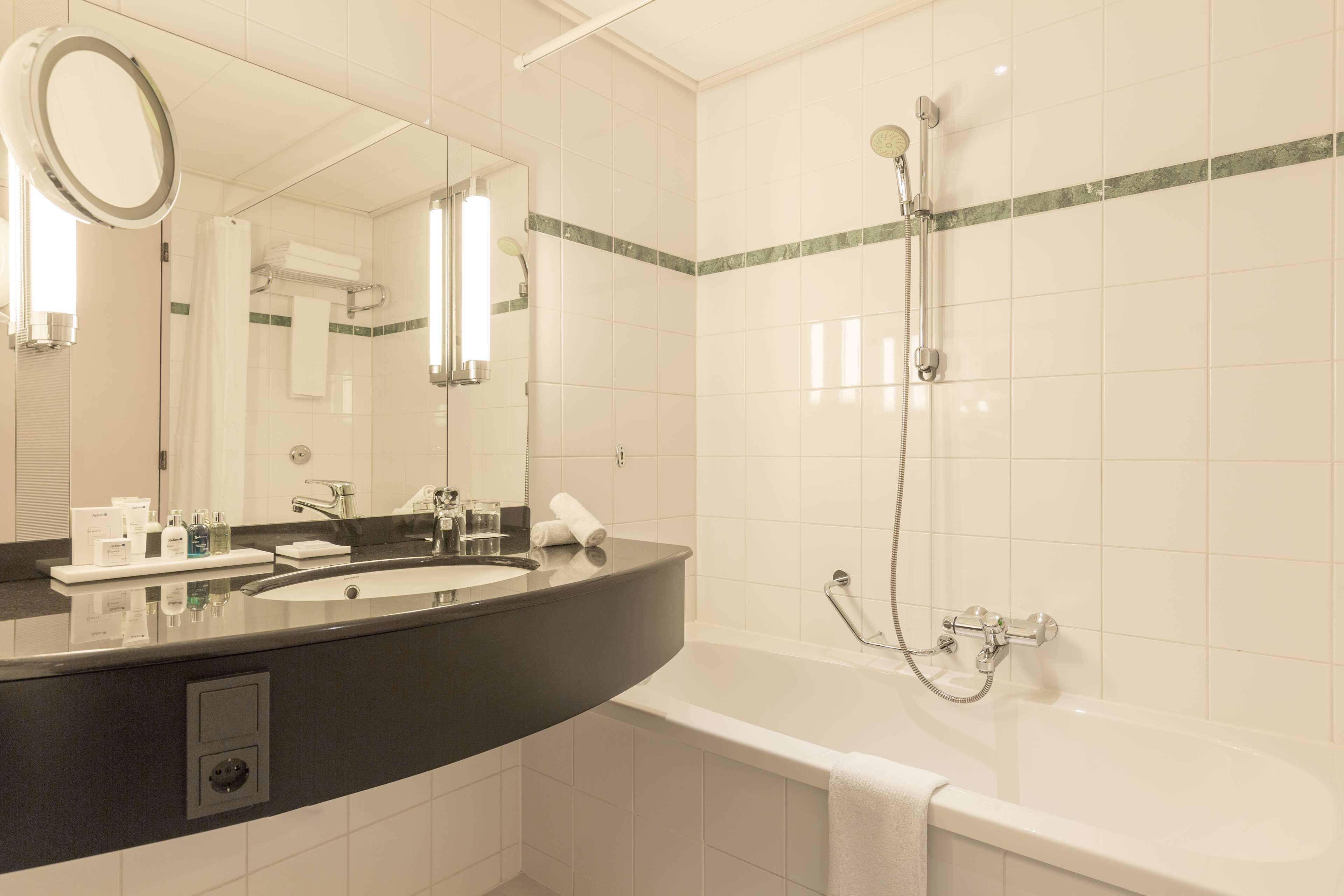Un bagno moderno con doppio lavandino, uno specchio grande, una doccia e una vasca da bagno.