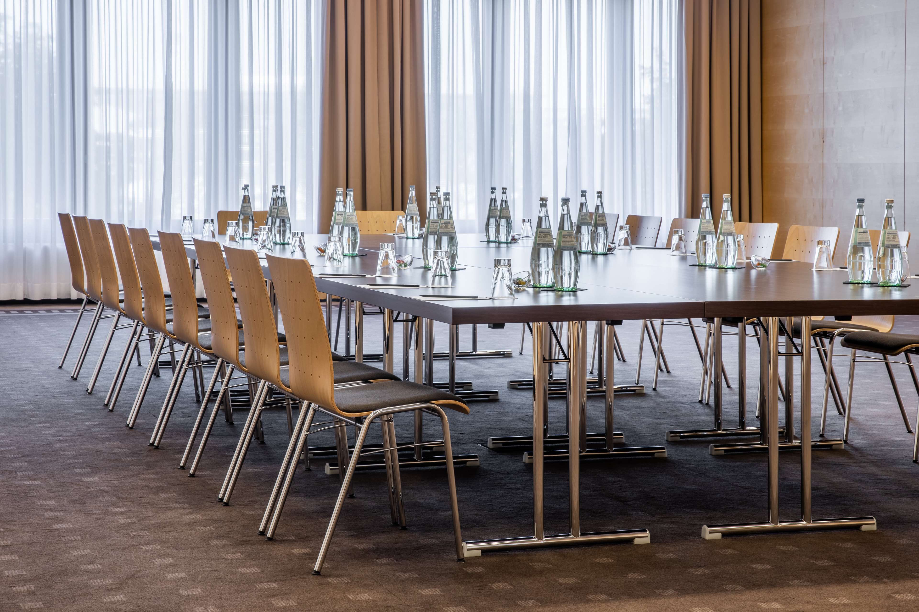 A conference room with a long table, chairs, and water bottles.