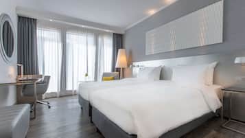 Ein modernes Hotelzimmer mit einem großen Bett, einem Schreibtisch und einem Sessel.