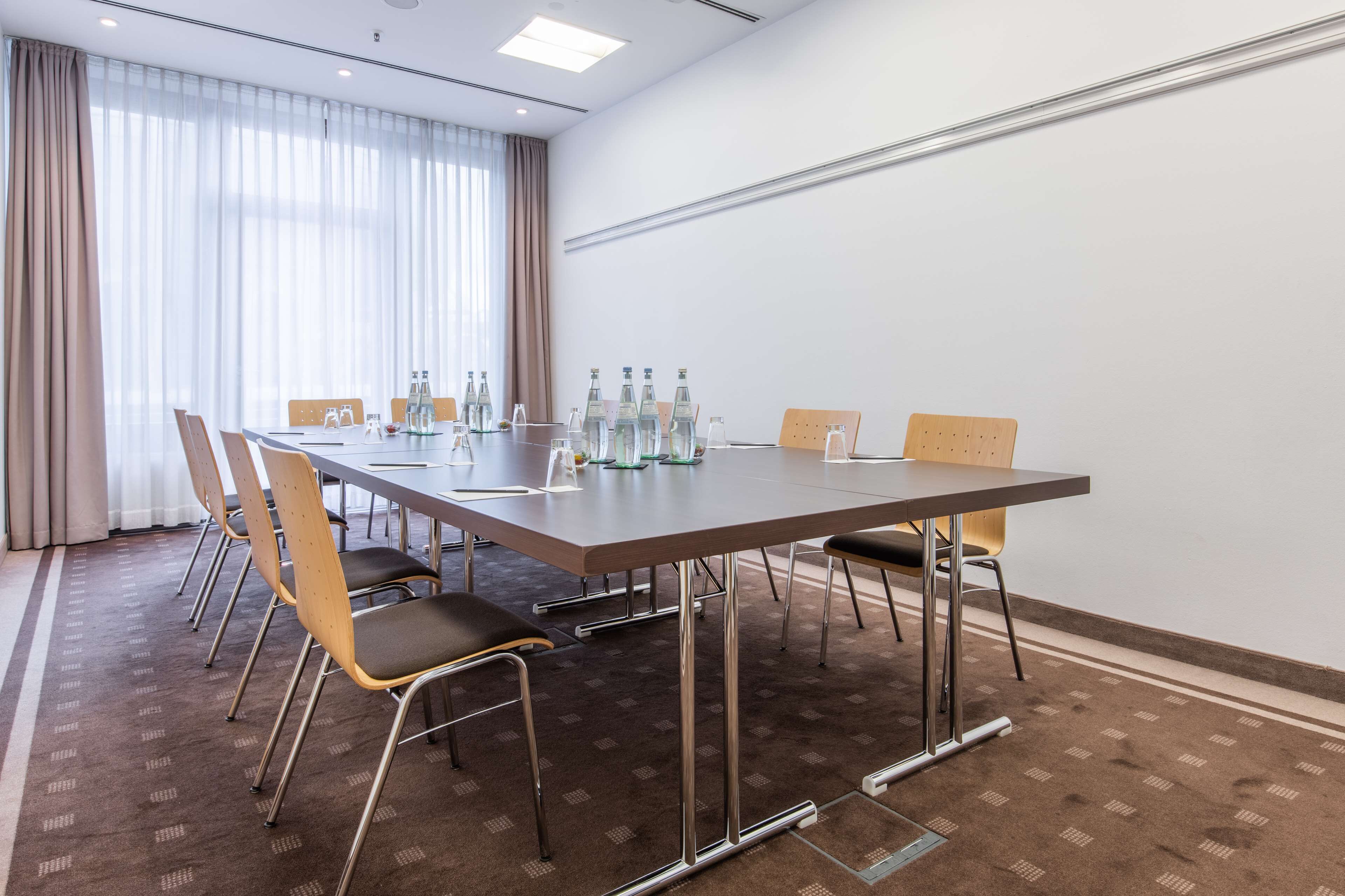 A conference room with a long table, chairs, and water bottles.