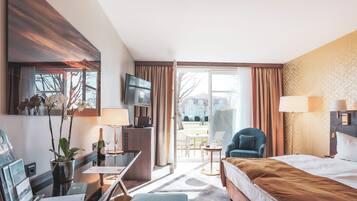 A hotel room with a bed, desk, chair, and a view of the outdoors.