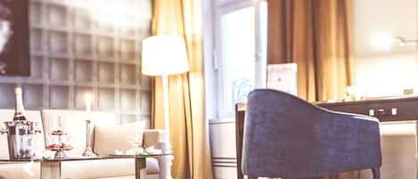 Habitación de hotel con un ventanal grande, un sofá, una lámpara y una silla.
