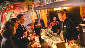 Una zona de bar donde un bartender sirve bebidas a los clientes.