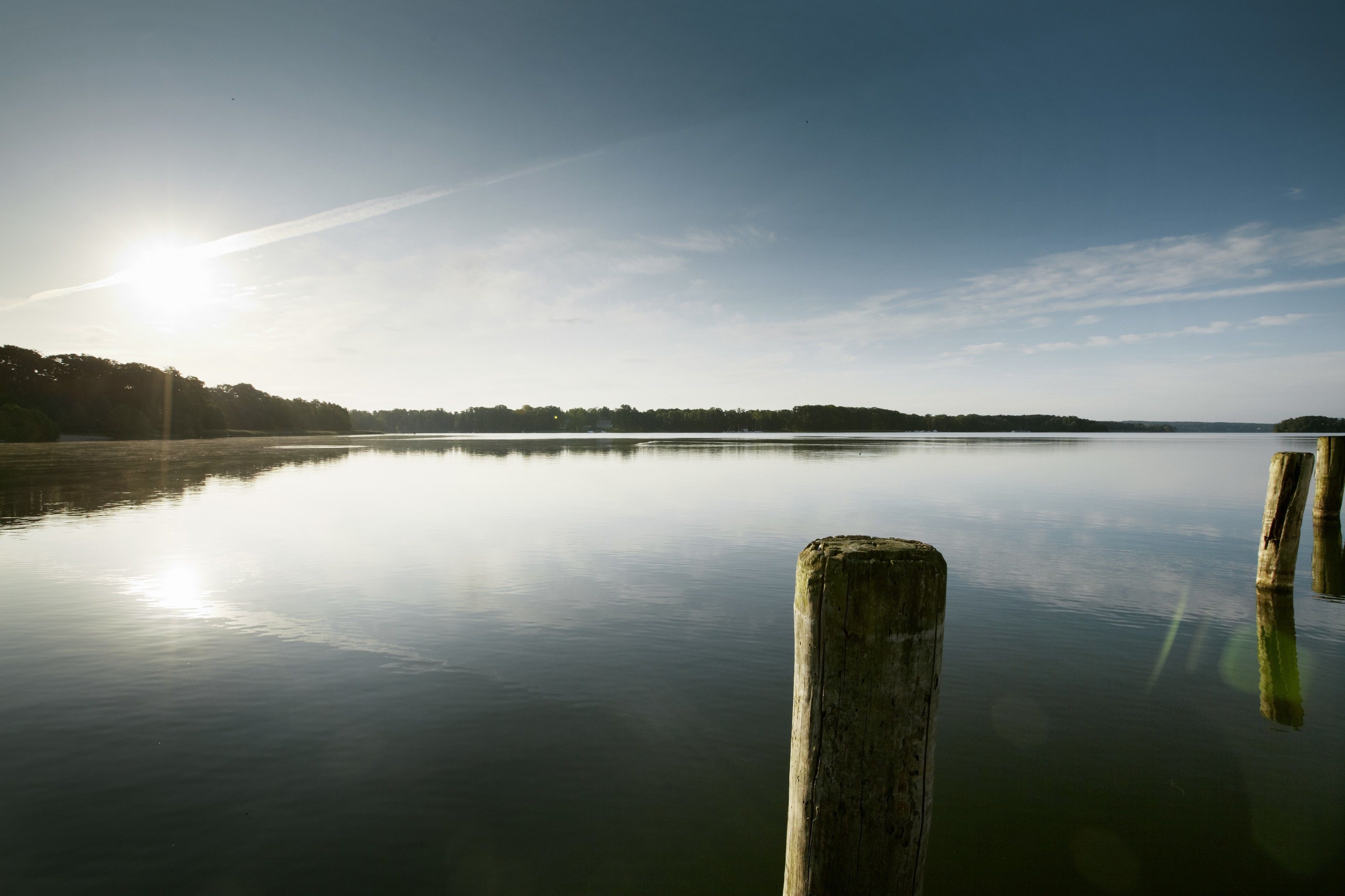 Un lac paisible, avec une jetée en bois qui s’avance sur l’eau.