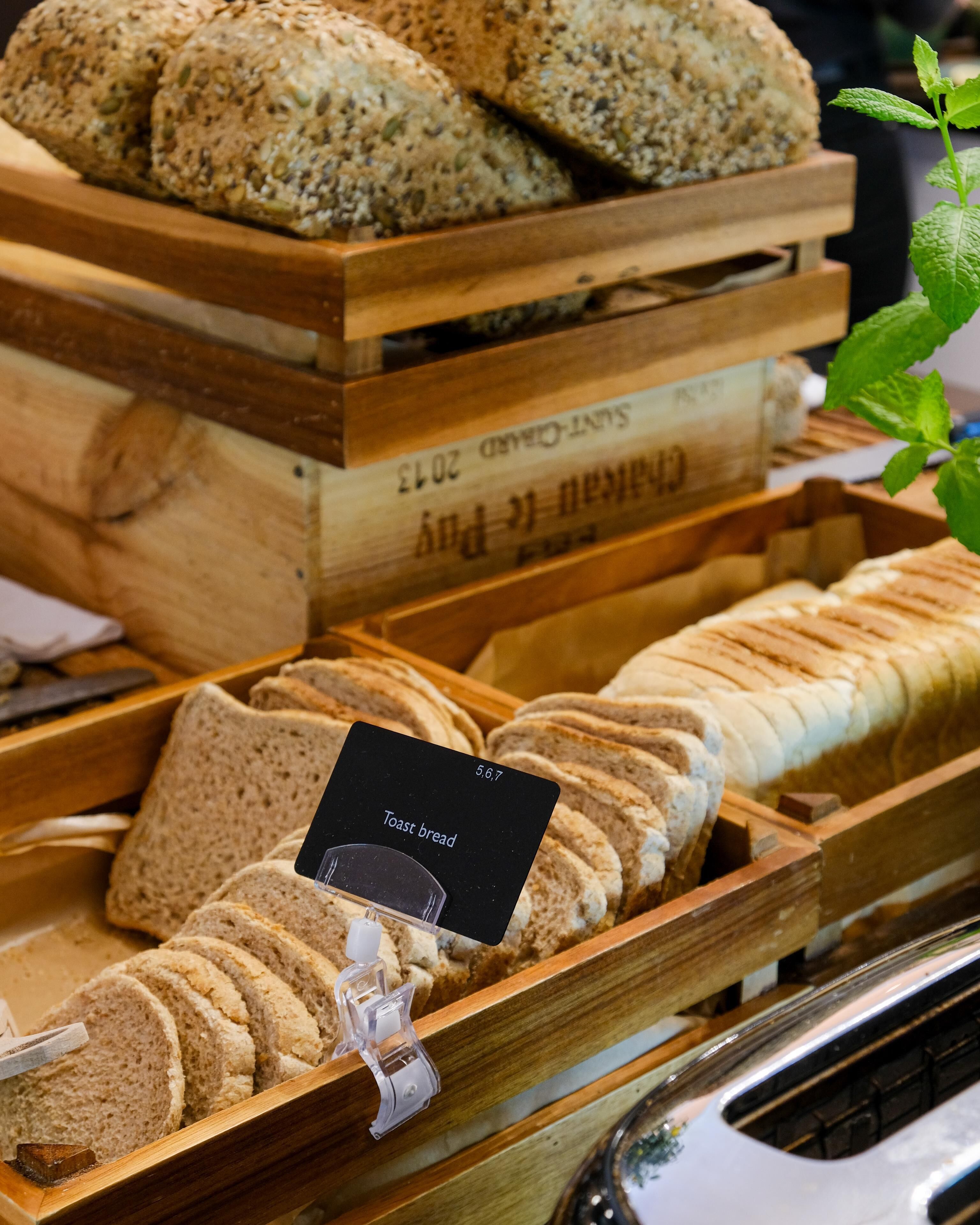 Mostrador de panadería con distintos tipos de pan, incluyendo integral y rebanado.