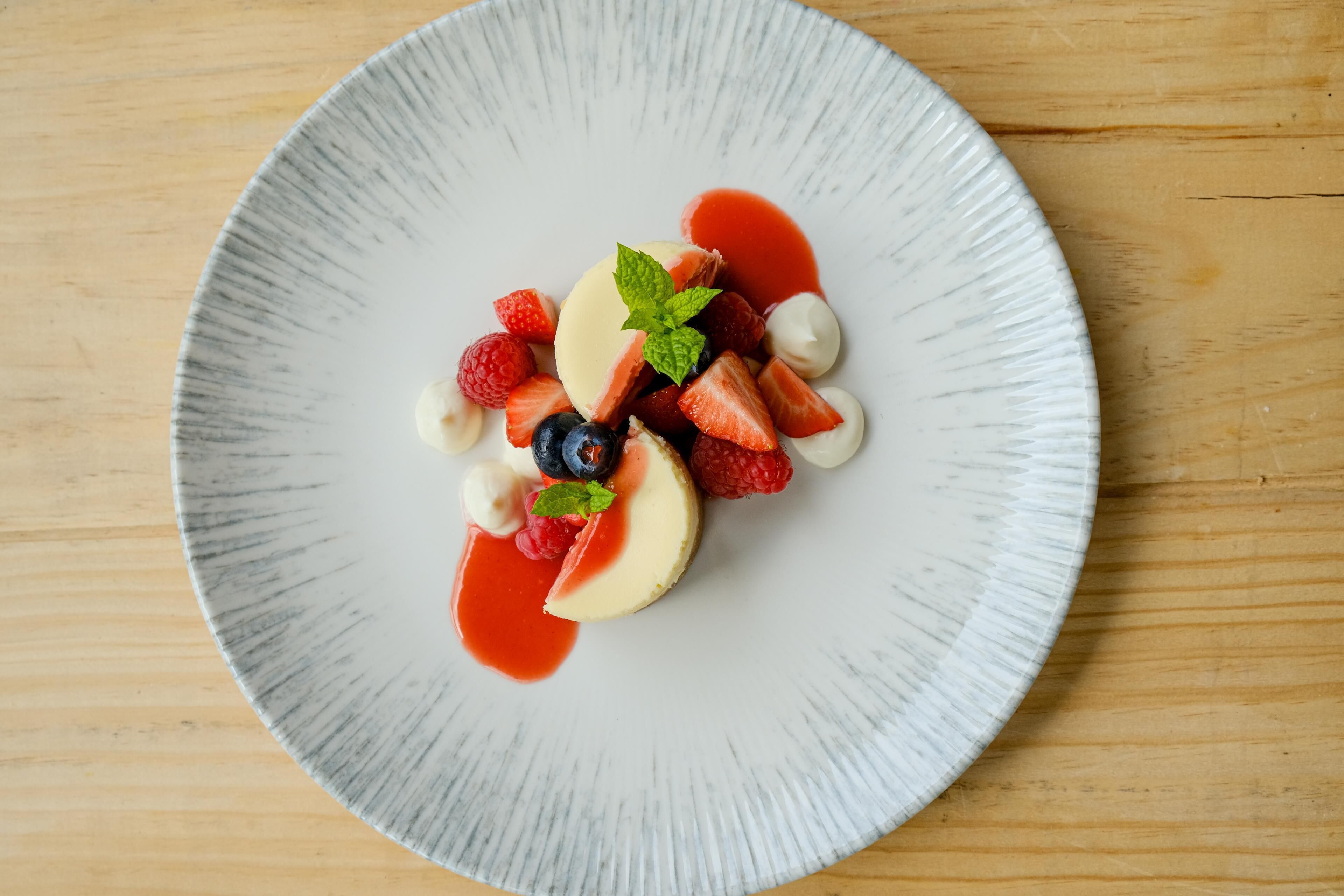 A white plate with a dessert on a wooden table.