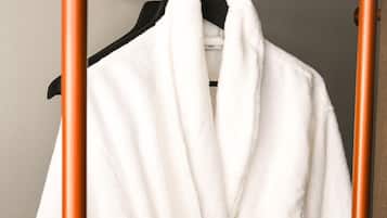 A white robe hanging on a wooden rack.