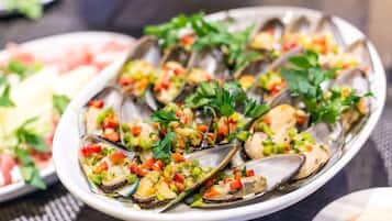A plate of oysters garnished with herbs and diced vegetables.