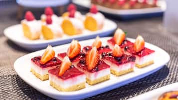 Un plateau de desserts variés, présentés sur une assiette blanche et décorés de fruits.