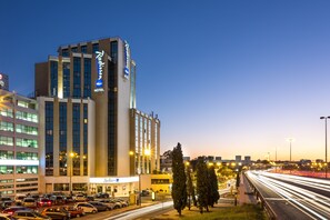 A Radisson hotel with a modern design, featuring a prominent sign and multiple floors. - Radisson Blu Hotel (Lisbon)