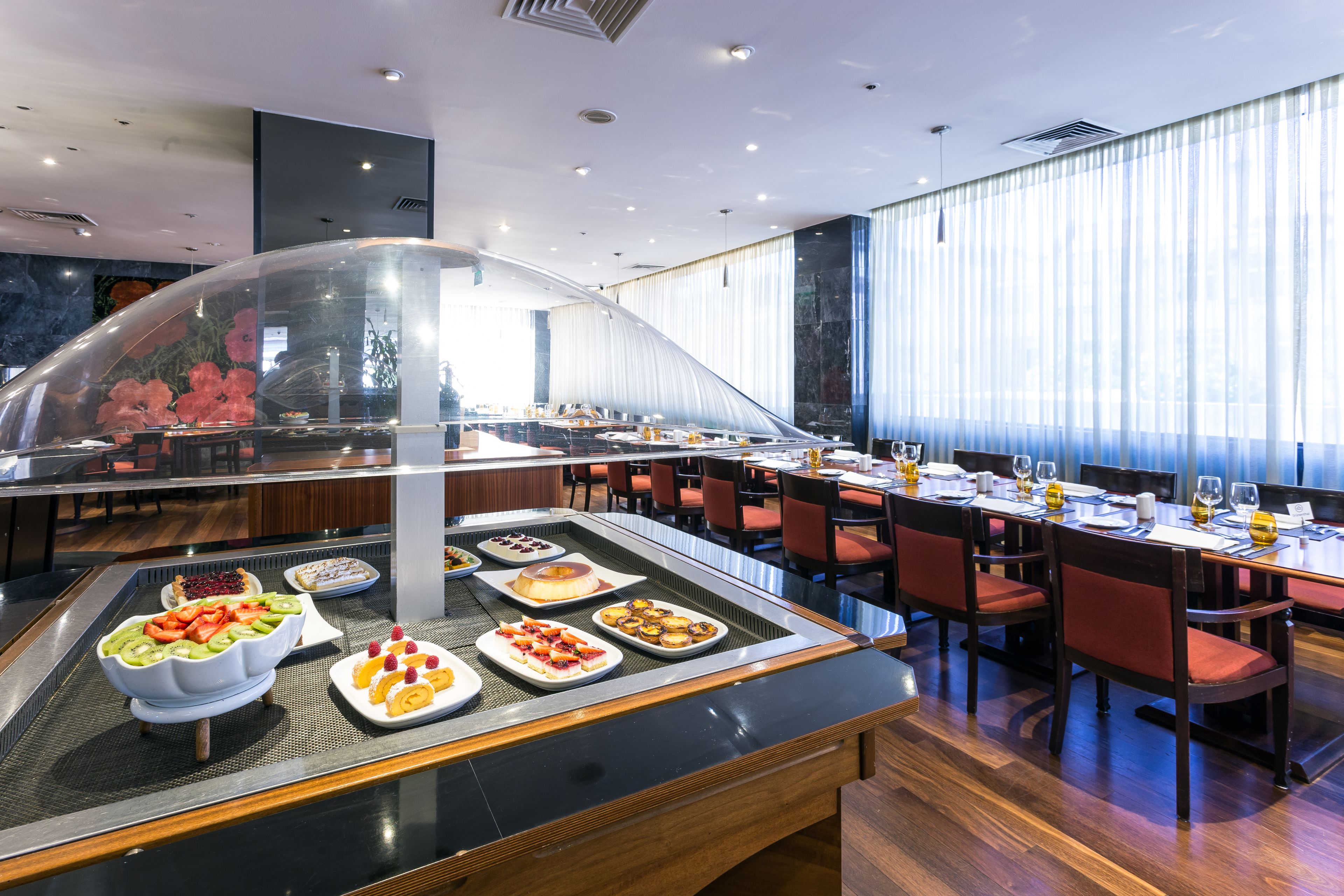 A buffet area with various food items and a seating arrangement with tables and chairs.
