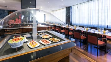 A buffet area with various food items and a seating arrangement with tables and chairs.