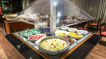 Een buffet met diverse gerechten en een afgedekt presentatiegedeelte.