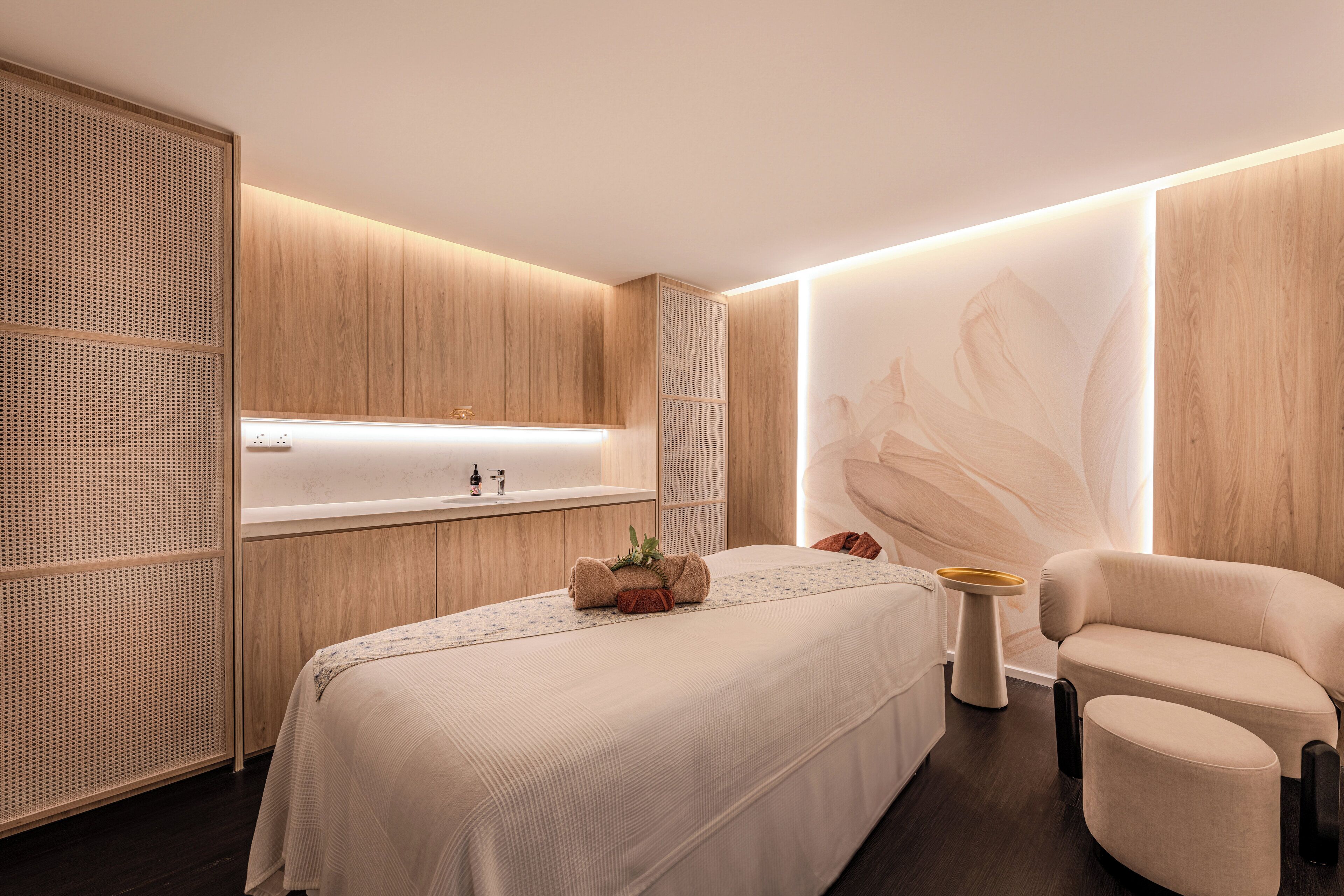 Un dormitorio moderno con una cama grande, una mesita de noche, una silla y un armario empotrado.