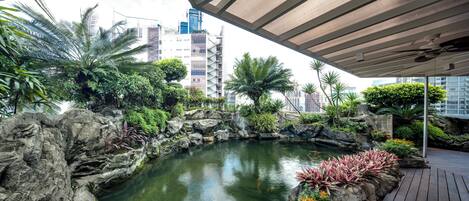 A landscaped garden with a pond, rocks, and various plants.