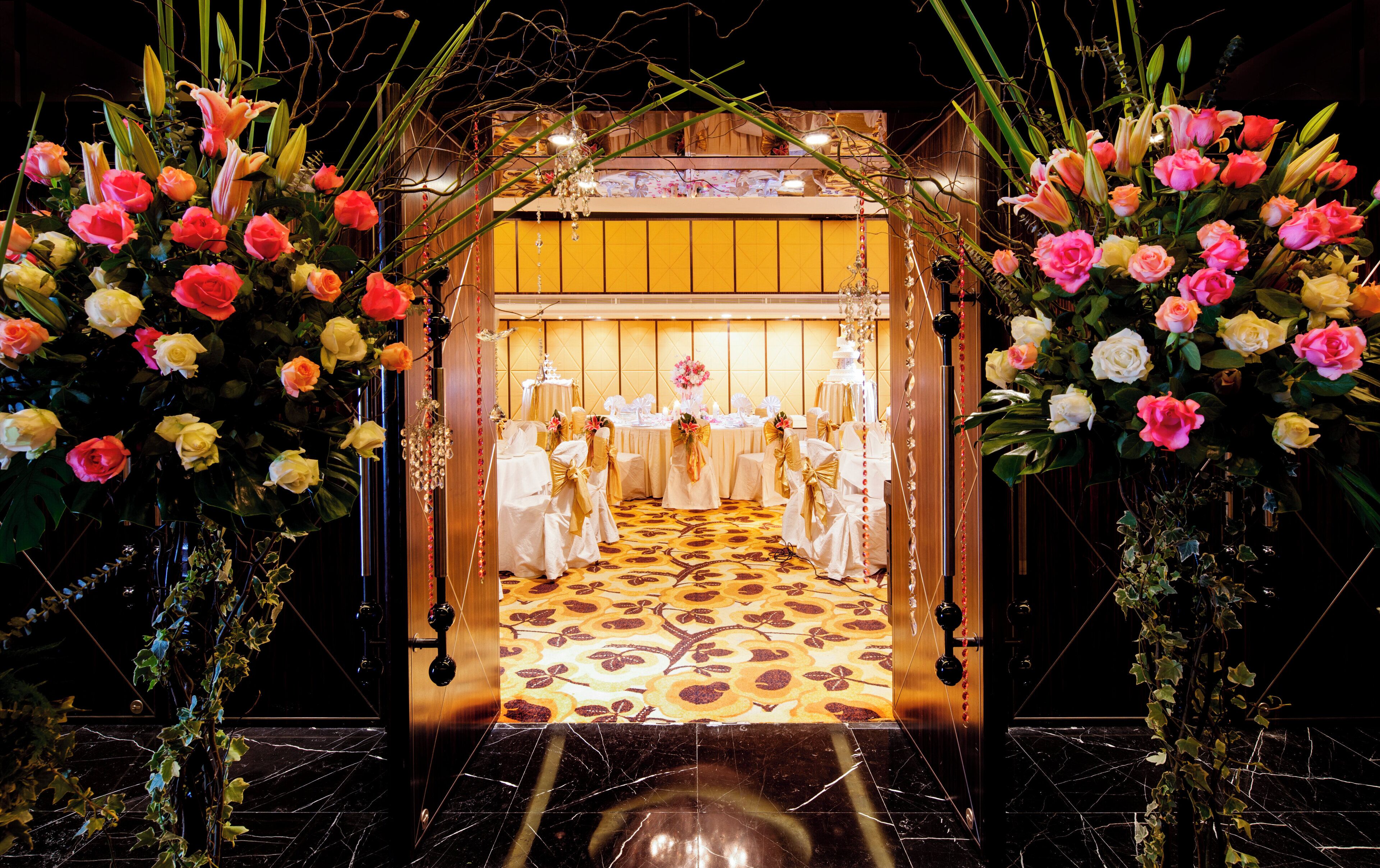 A reception area with a marble floor, a reception desk, and a wall with a patterned design.
