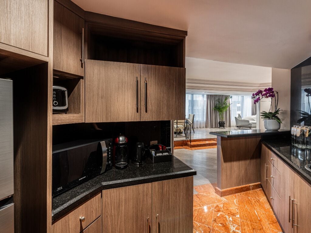 A modern kitchen with built-in appliances, a marble countertop, and wooden cabinetry.