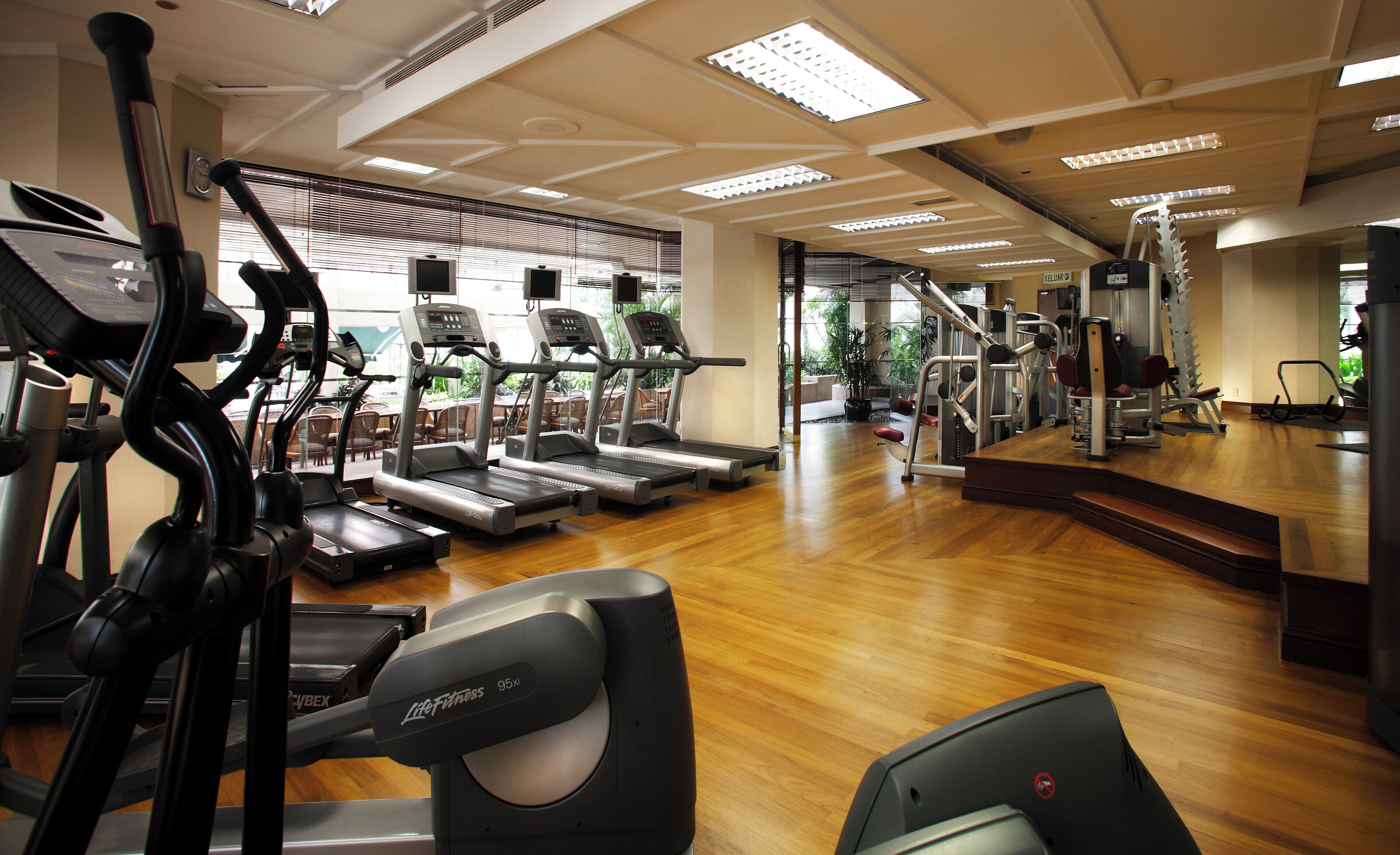 Un gimnasio con cintas de correr, elípticas y máquinas de pesas.