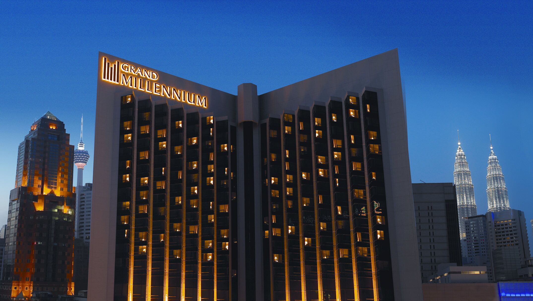 A modern hotel with a prominent sign reading "Grand Millennium."