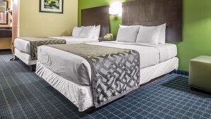 A hotel room with two beds, green walls, a ceiling fan, and a framed picture on the wall.