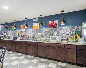 A breakfast bar with a checkered floor, a microwave, a toaster, and a refrigerator.