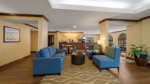 A spacious living area with a sofa set, a coffee table, and a dining area with chairs and a table. - Comfort Inn Fayetteville I-95 (Fayetteville)