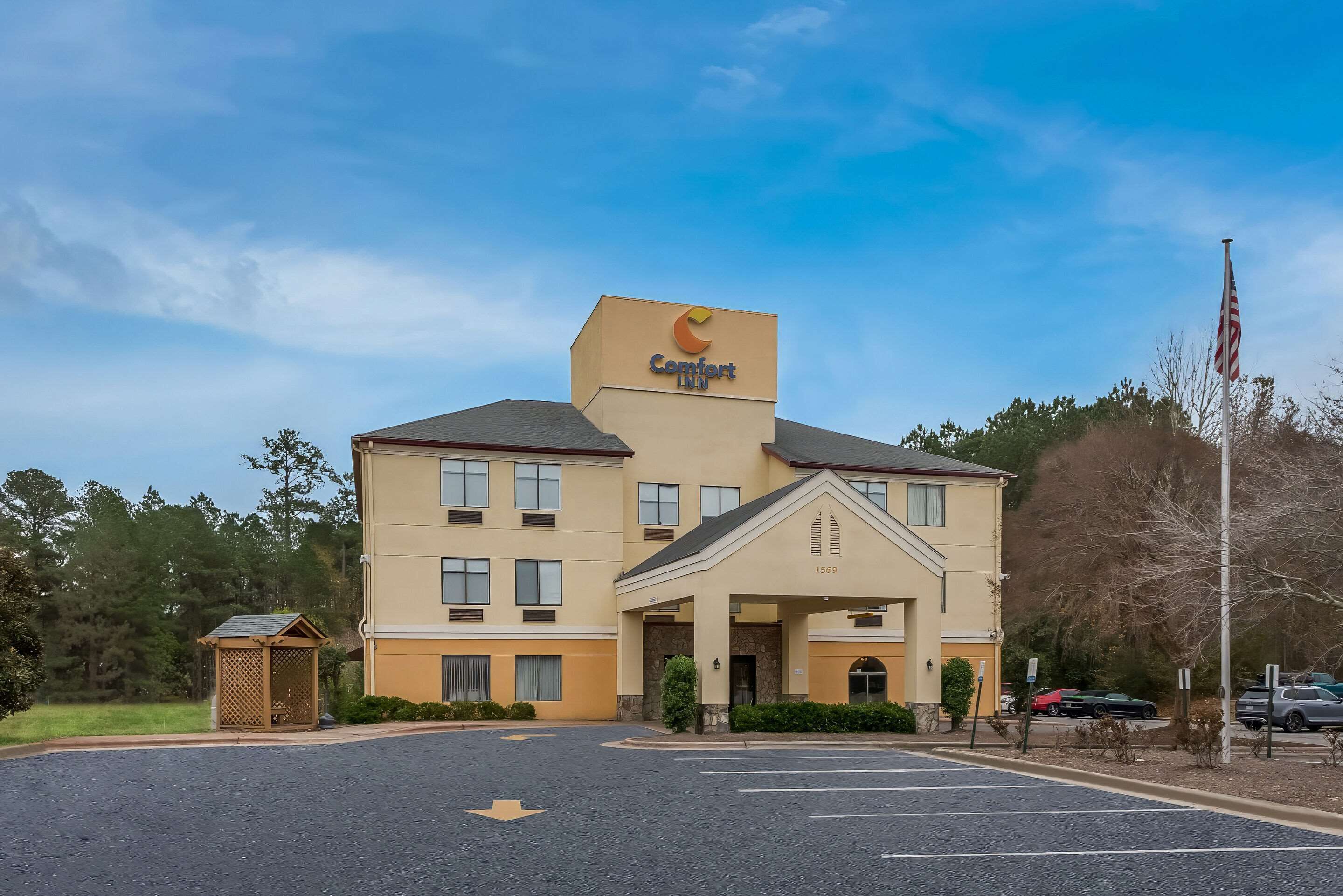 Un hotel Comfort Inn con un edificio de dos pisos, un acceso cubierto y un estacionamiento.