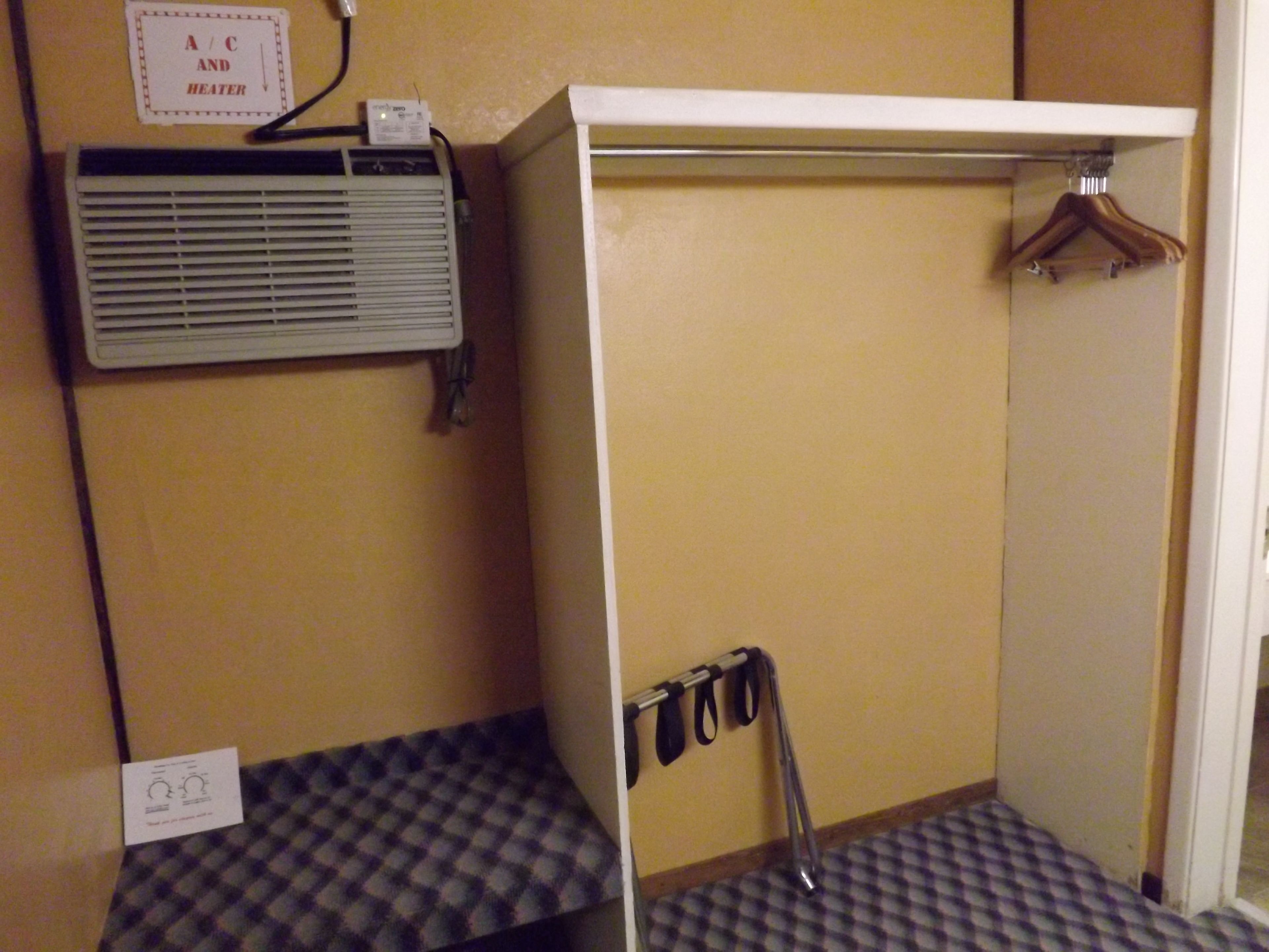 A bathroom with a towel rack, a heater, and a sign indicating A/C and heater availability.