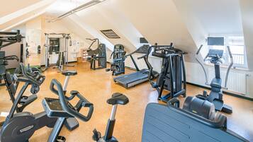 A gym with various exercise equipment, including treadmills, elliptical machines, and weight machines.