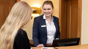 A reception desk with a name tag, a laptop, and some documents.