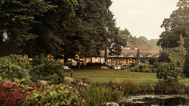 A traditional building with a garden and pond.