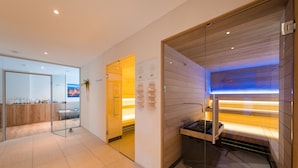 A modern hotel room with a glass partition, a wooden panel wall, and a built-in bench. - DORMERO Hotel Coburg (Coburg)