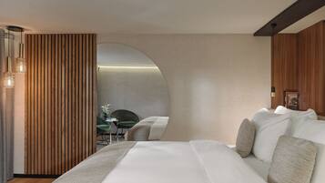 Een moderne hotelkamer met een groot bed, een wand van houten panelen en uitzicht op een eetruimte.
